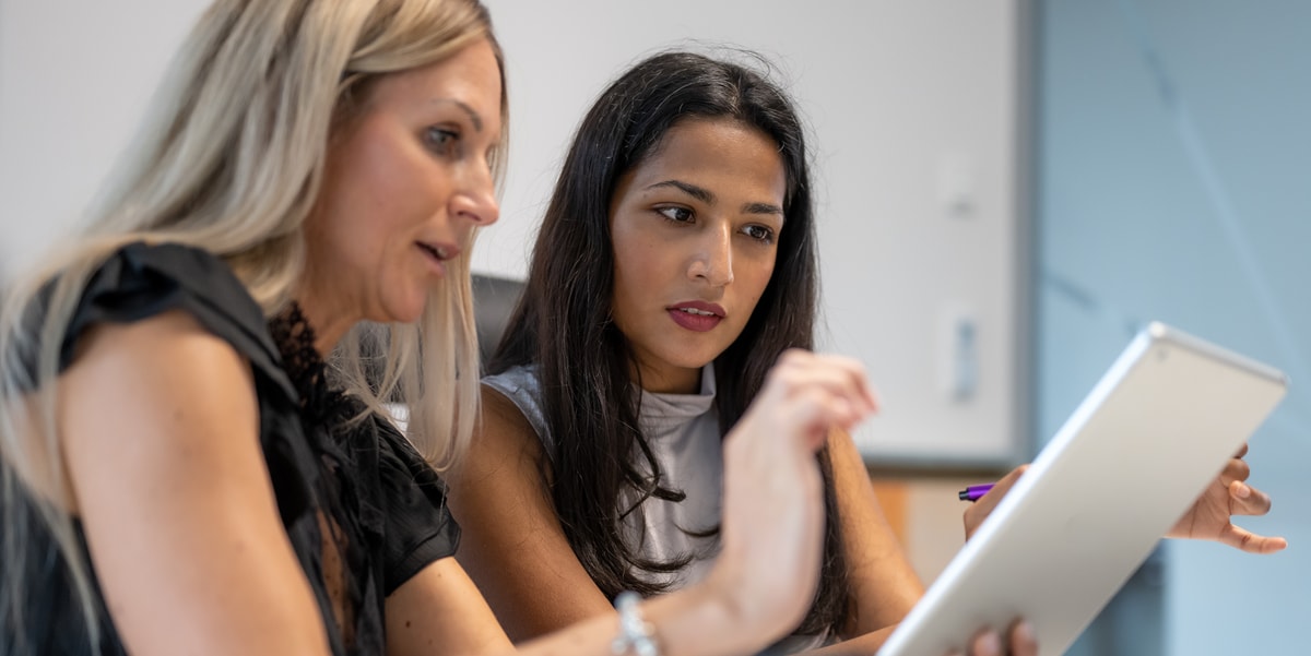 Two businesswomen looking at a tablet together