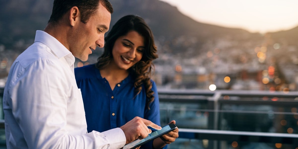 two people looking at phone standing outdoors