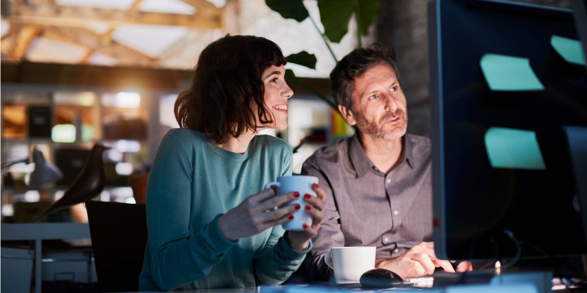 two people working on a computer together at night